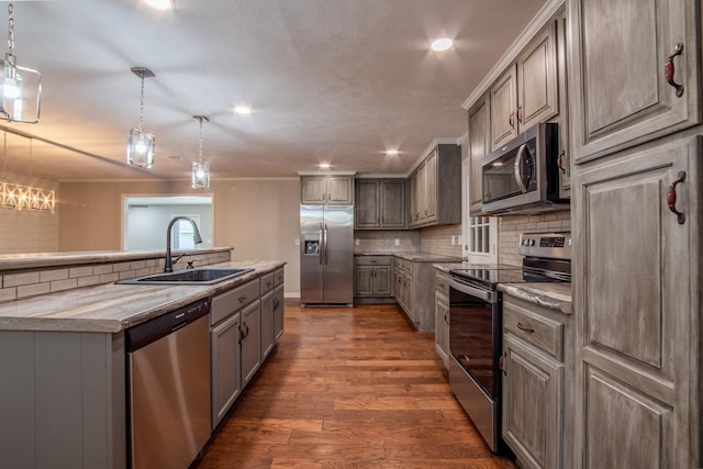 kitchen with decorative light fixtures, sink, gray cabinetry, and stainless steel appliances