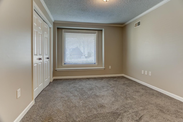 unfurnished room with crown molding, a textured ceiling, and carpet flooring