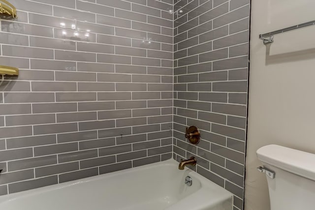 bathroom featuring toilet and tiled shower / bath