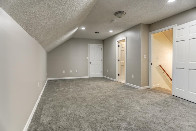 bonus room with a textured ceiling, carpet flooring, and vaulted ceiling