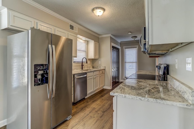 kitchen with sink, light stone countertops, appliances with stainless steel finishes, a textured ceiling, and white cabinets