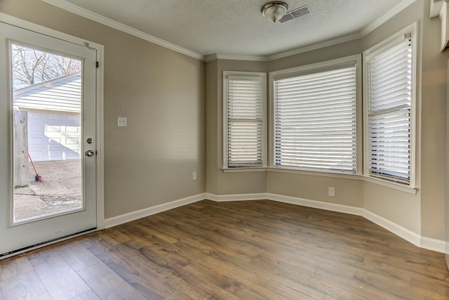 spare room featuring a textured ceiling, crown molding, and hardwood / wood-style floors