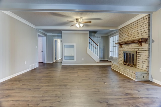 unfurnished living room with ceiling fan, wood-type flooring, a brick fireplace, and a textured ceiling