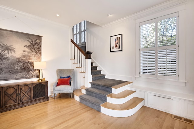 staircase featuring crown molding and wood-type flooring