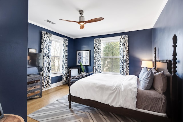 bedroom featuring ceiling fan, hardwood / wood-style floors, and ornamental molding