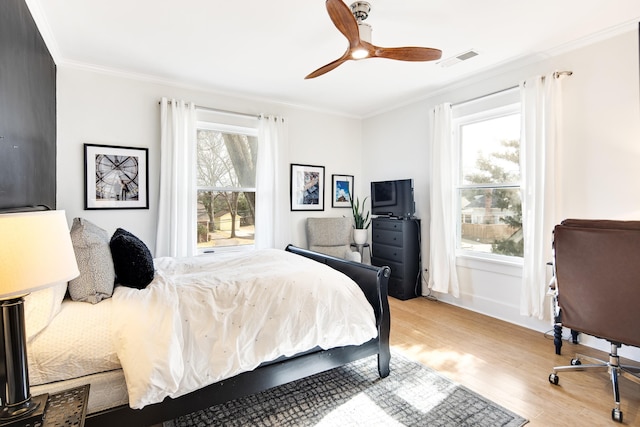 bedroom with ceiling fan, light wood-type flooring, and ornamental molding