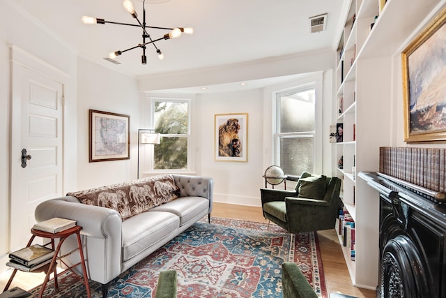 living room with hardwood / wood-style flooring, ornamental molding, and a notable chandelier