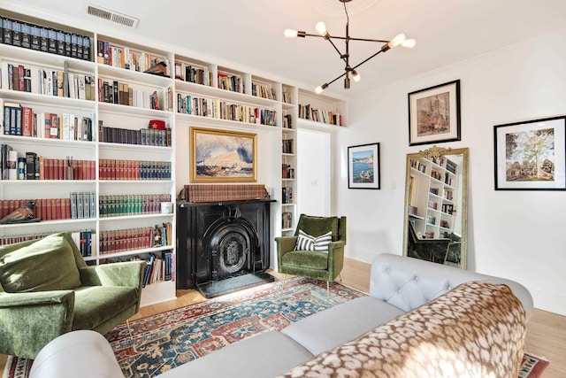 sitting room featuring wood-type flooring and a chandelier