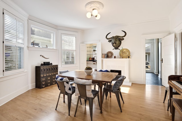 dining area featuring a wealth of natural light, light hardwood / wood-style flooring, and ornamental molding