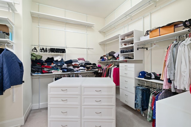 walk in closet with light carpet