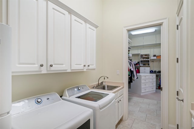 laundry area with cabinets, washer and dryer, and sink