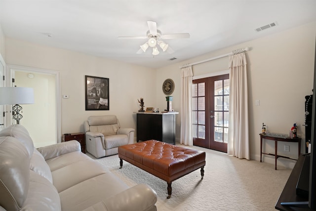 carpeted living room with ceiling fan and french doors