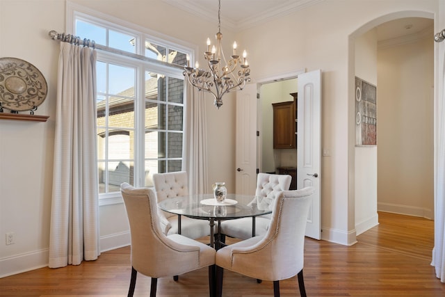 dining room with crown molding, a chandelier, and hardwood / wood-style flooring