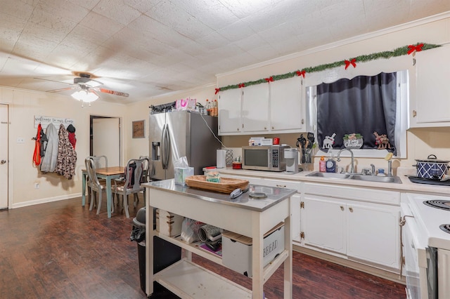 kitchen with dark hardwood / wood-style floors, appliances with stainless steel finishes, white cabinetry, and sink