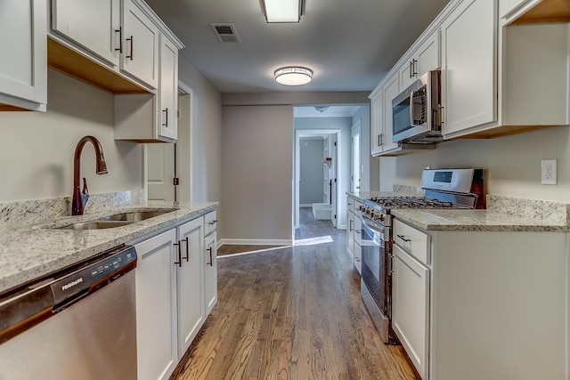 kitchen featuring sink, hardwood / wood-style flooring, stainless steel appliances, and white cabinets