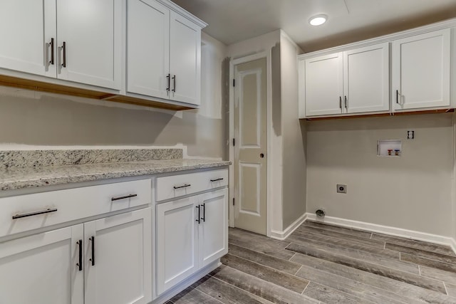 laundry room featuring hardwood / wood-style flooring, cabinets, hookup for an electric dryer, and hookup for a washing machine