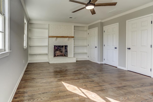 unfurnished living room with dark hardwood / wood-style floors, built in features, ceiling fan, crown molding, and a brick fireplace