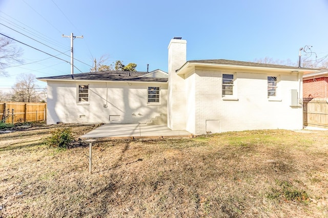 rear view of property featuring a lawn and a patio area