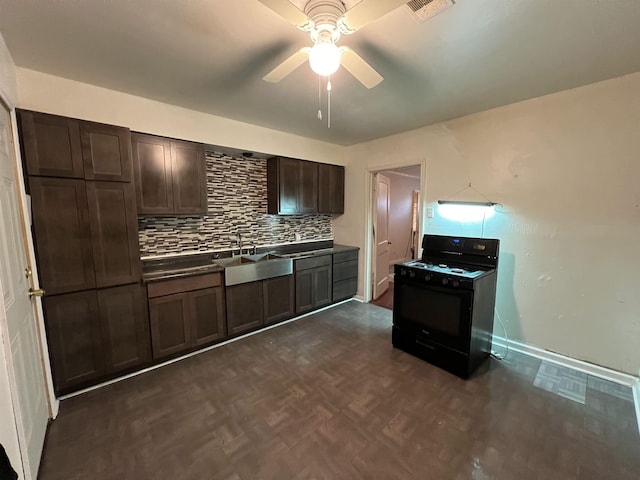 kitchen featuring black gas range, ceiling fan, dark parquet flooring, dark brown cabinetry, and sink