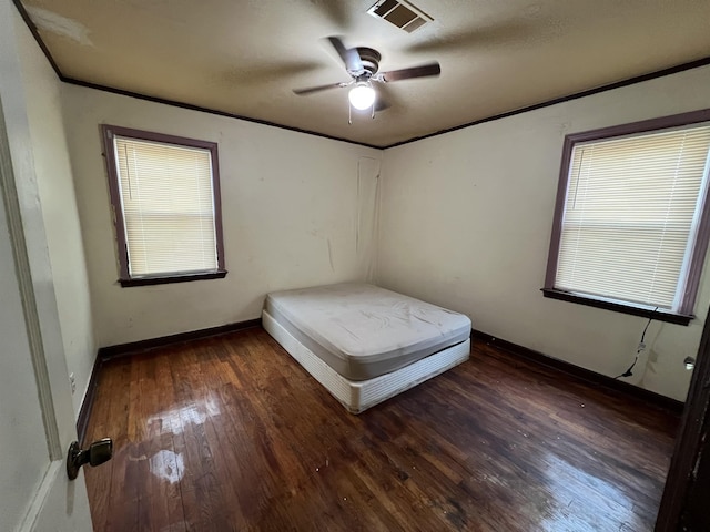 unfurnished bedroom featuring ceiling fan, dark hardwood / wood-style flooring, and ornamental molding