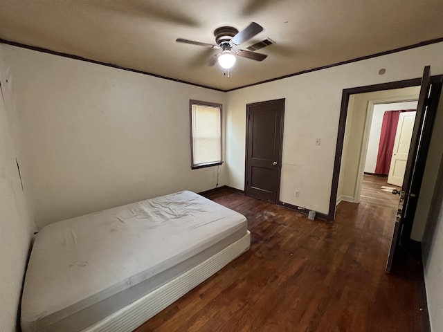 unfurnished bedroom featuring ceiling fan, crown molding, and dark hardwood / wood-style floors