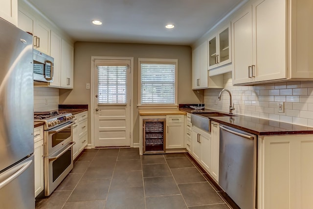 kitchen featuring wine cooler, white cabinets, decorative backsplash, and stainless steel appliances