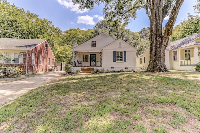 view of front facade with covered porch, a front lawn, and central AC