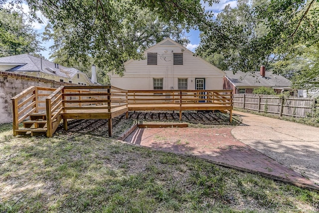 rear view of property featuring a deck and a patio