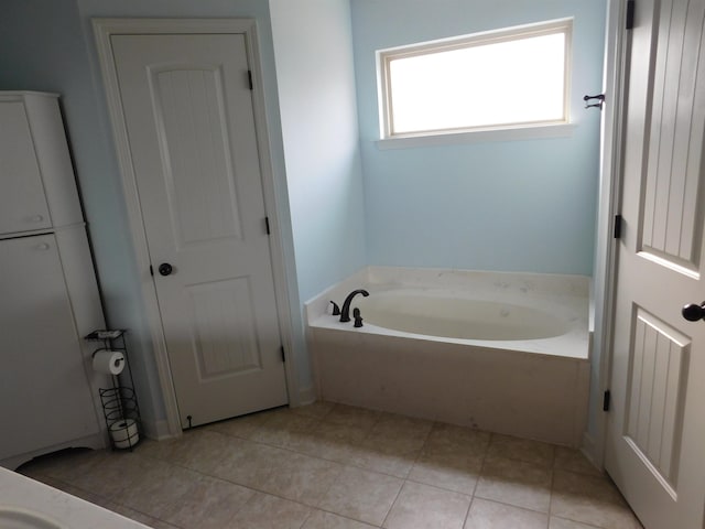 bathroom featuring tile patterned flooring and a bath