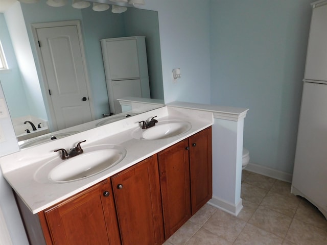 bathroom with a sink, toilet, and double vanity