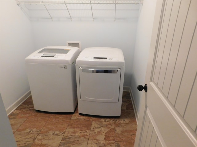 laundry area featuring laundry area, separate washer and dryer, and baseboards