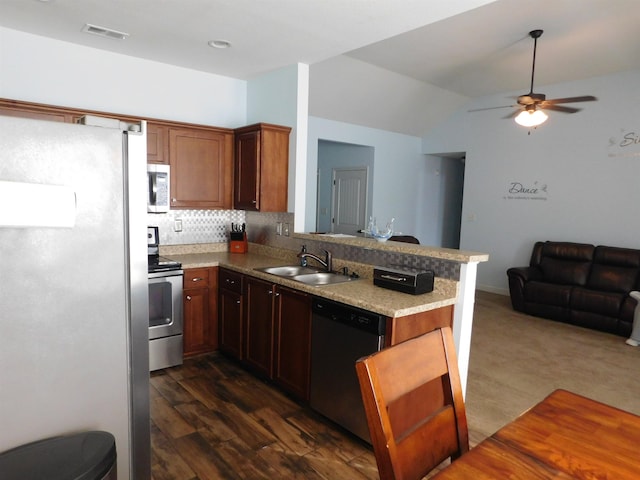 kitchen with visible vents, a peninsula, a sink, appliances with stainless steel finishes, and open floor plan