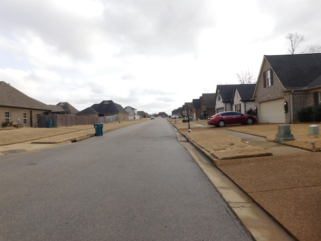 view of road featuring sidewalks, a residential view, and curbs