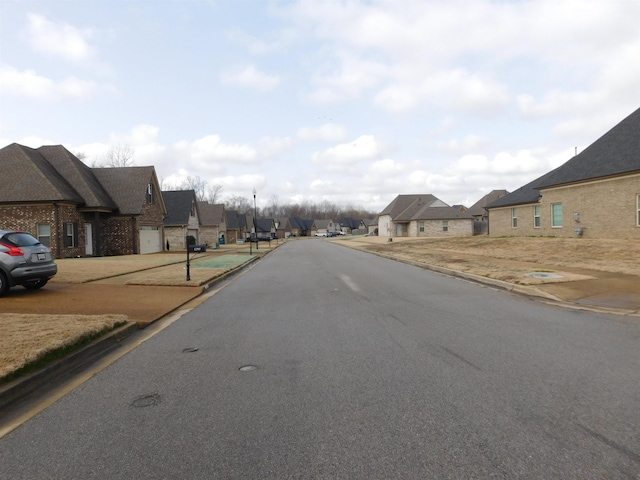 view of street featuring a residential view and curbs