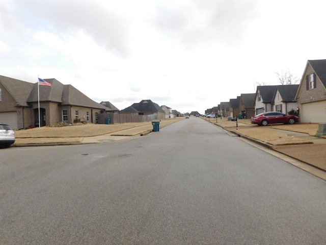 view of street featuring a residential view, curbs, and sidewalks