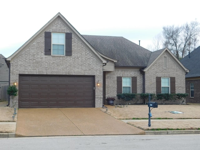 traditional-style home featuring brick siding, concrete driveway, and roof with shingles