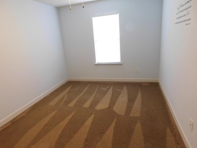 unfurnished room featuring baseboards and carpet floors