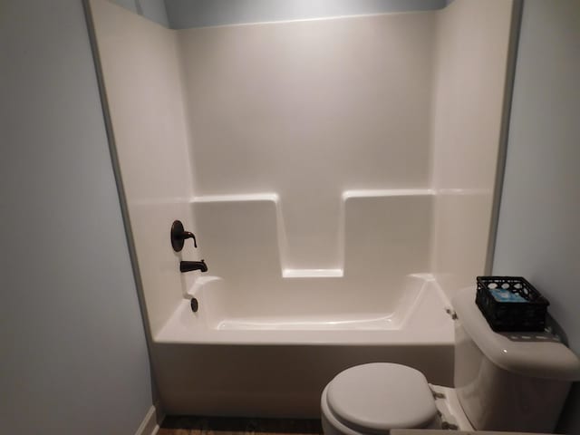 bathroom featuring toilet and washtub / shower combination