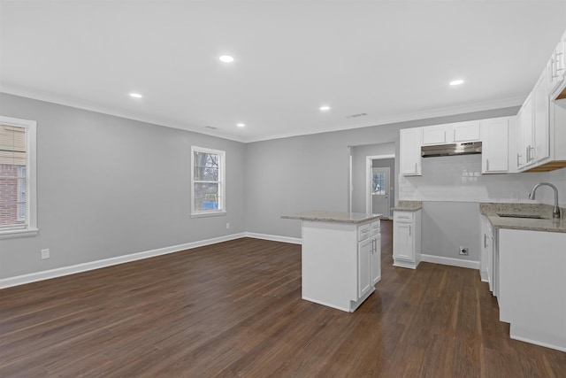 kitchen featuring a kitchen island, sink, crown molding, white cabinetry, and dark hardwood / wood-style flooring