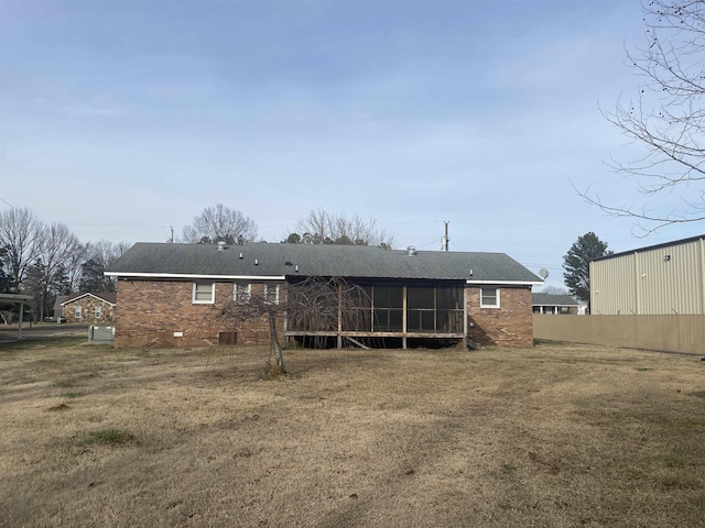 back of property with a yard and a sunroom