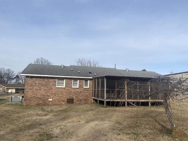 rear view of property with a sunroom and a lawn