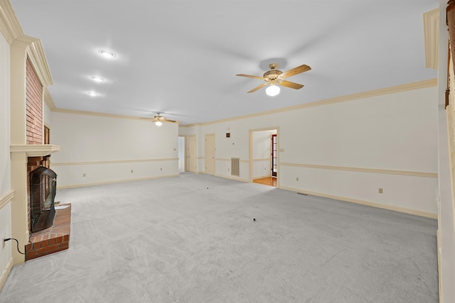 unfurnished living room with ornamental molding, light colored carpet, ceiling fan, and a fireplace