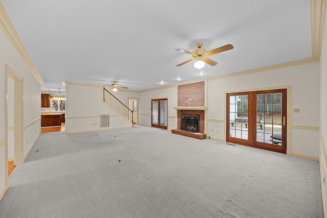 unfurnished living room with ornamental molding, light carpet, ceiling fan, and french doors