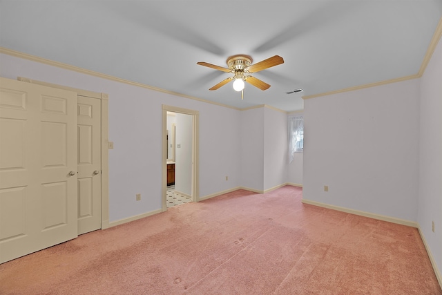 unfurnished bedroom with light carpet, crown molding, ceiling fan, and ensuite bathroom