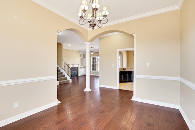 empty room featuring crown molding, baseboards, and dark wood-style flooring