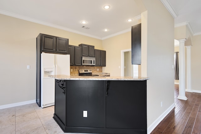 kitchen featuring a kitchen breakfast bar, ornamental molding, stainless steel appliances, and decorative columns