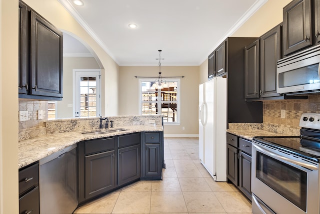 kitchen with hanging light fixtures, stainless steel appliances, crown molding, a sink, and light tile patterned flooring