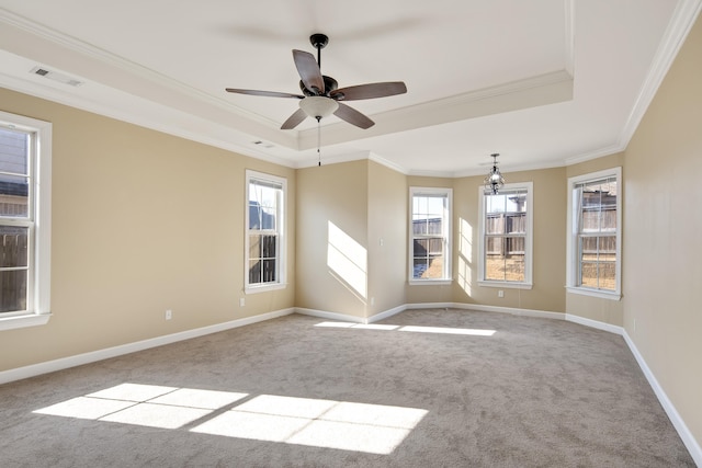 unfurnished room featuring a tray ceiling, light carpet, visible vents, and baseboards