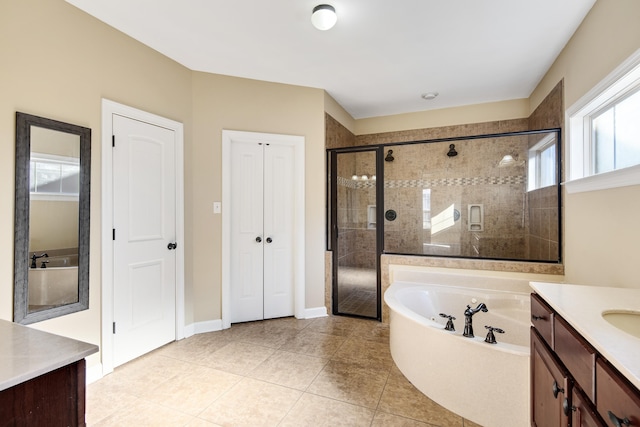 bathroom with a stall shower, tile patterned floors, a garden tub, vanity, and a closet