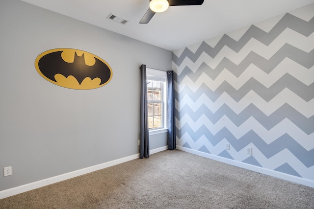 unfurnished room featuring an accent wall, carpet floors, visible vents, and baseboards